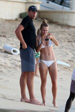 Caroline wozniacki slips into a white bikini while enjoying a beach day with husband david lee